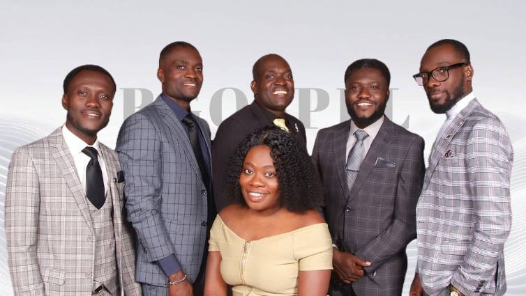 Photo de groupe des sept membres de la famille Marcelus, vêtus d'habits élégants, dans une église ou un studio d'enregistrement